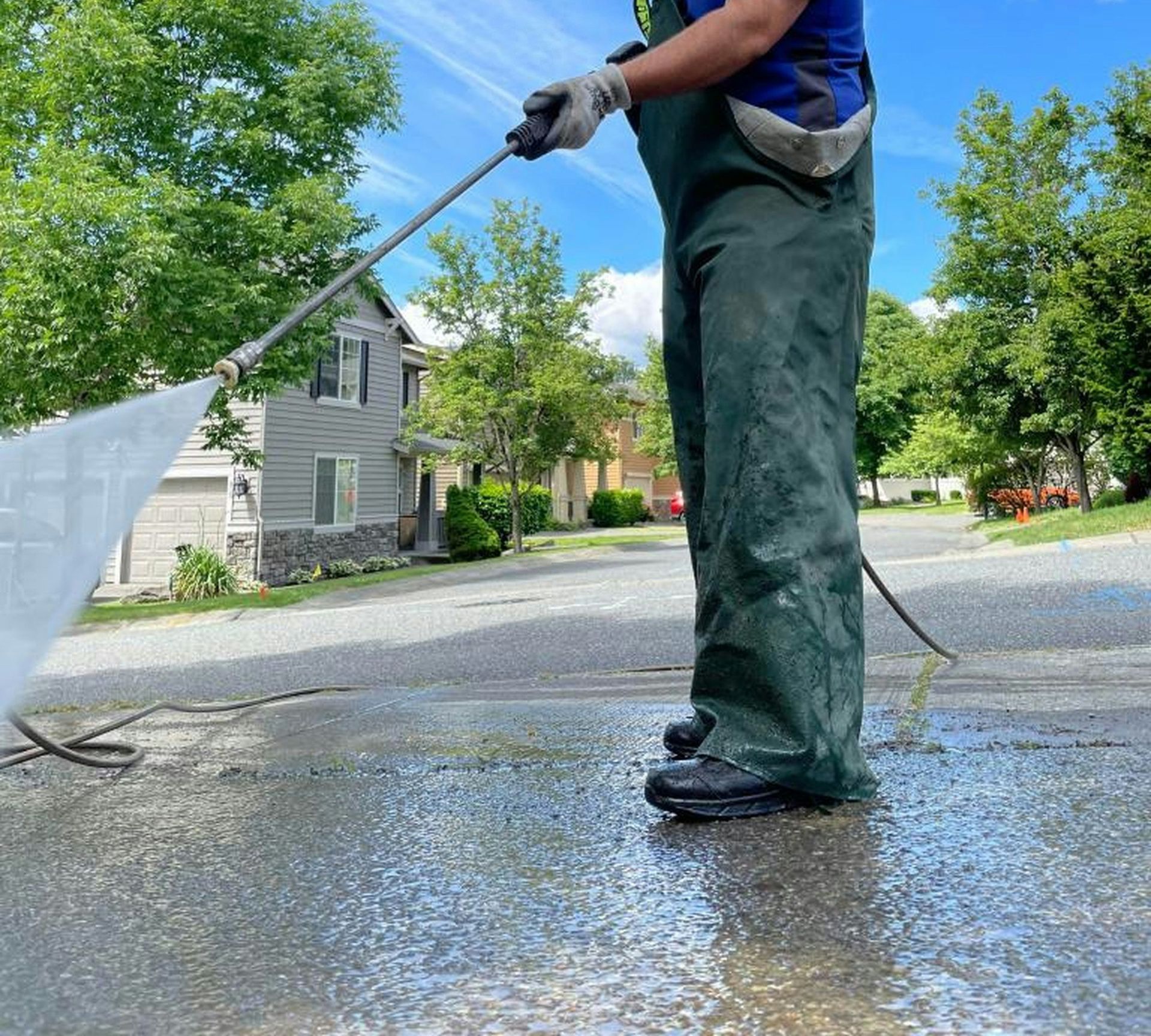 a man is cleaning the street with a hose